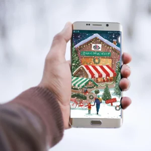Hand holding a phone with a virtual gift Christmas e-card on the screen